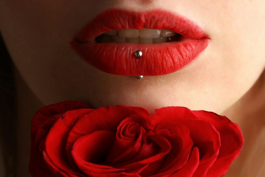 pexels-photo-1161931-1161931 Aesthetic close-up featuring red lipstick, lip piercing, and a red rose.